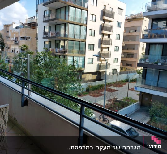 מעקה זכוכית במרפסת עם נוף לבניינים